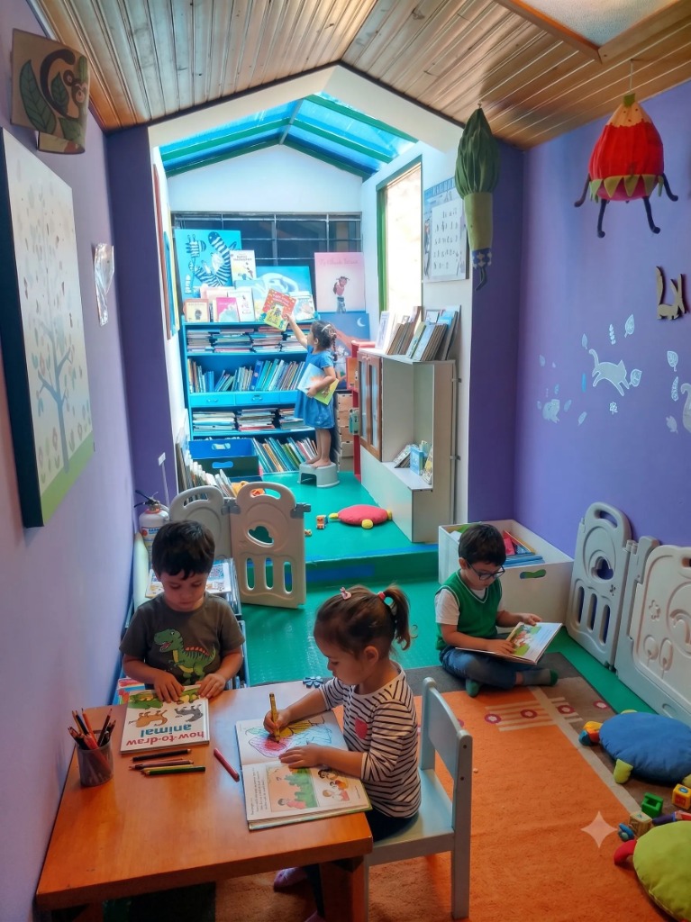 Niños leyendo y buscando libros en la biblioteca de Cosecha de Sueños
